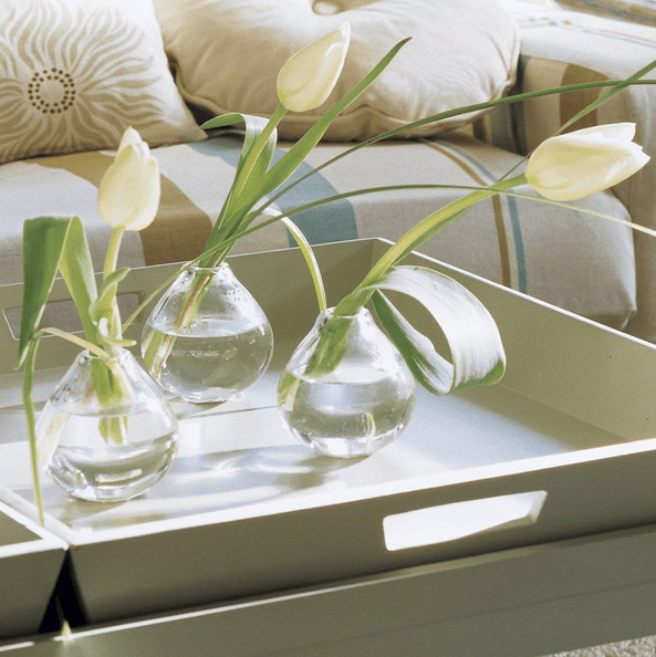 A white tray with clear vases and white tulips for contemporary chic as it is