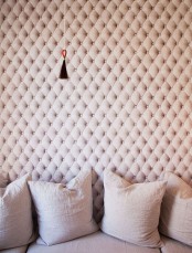 an upholstered tufted wall in blush isn’t only a catchy decor feature but also a cool soundproofing idea