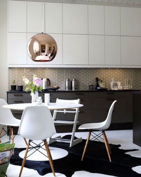 a black and white mid-century modern kitchen with a white dining set, a mosaic tile backsplash and a large copper lamp