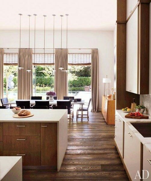 a white and rich-stained mid-century modern kitchen with neutral countertops and hardwood floors