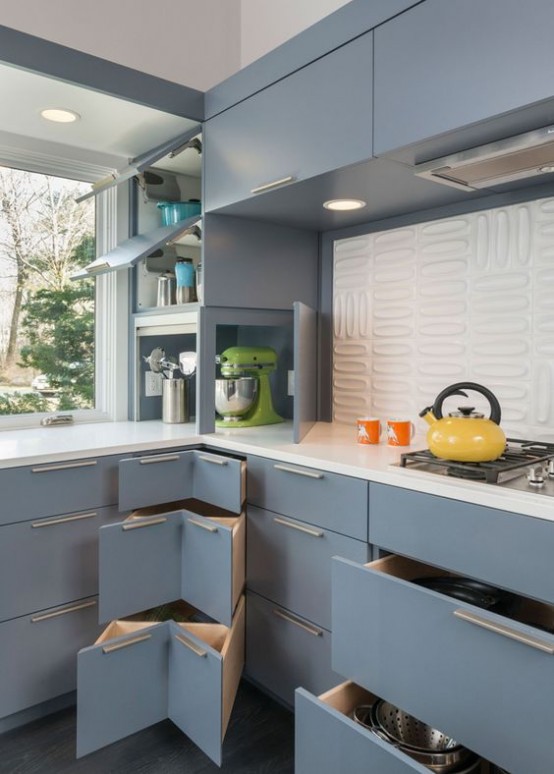 a light blue mid-century modern kitchen with white countertops and a white textural tile backsplash