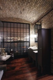 a contemporary bathroom doen with white brick walls, dark furniture, a shower, a vanity with a sink and an arched ceiling