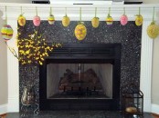 colorful paper Easter eggs hanging on the mantel and blooming branches in vases