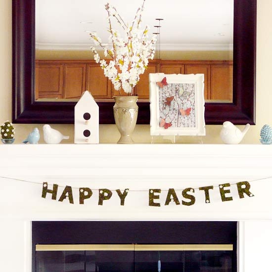 a neutral Easter mantel with fake birds, fake eggs, a butterfly artwork and blooming branches