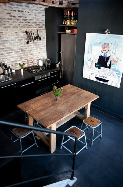 a whitewashed brick wall contrast the matte black cabinets and add texture to the space