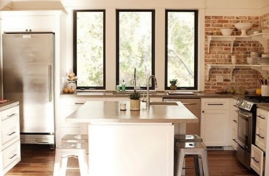 red bricks, shiny metal surfaces, simple white cabinets make up a stylish rustic meets industrial kitchen
