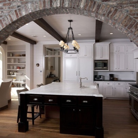 an exposed brick arched doorway adds texture to the space and makes it bolder and more chic