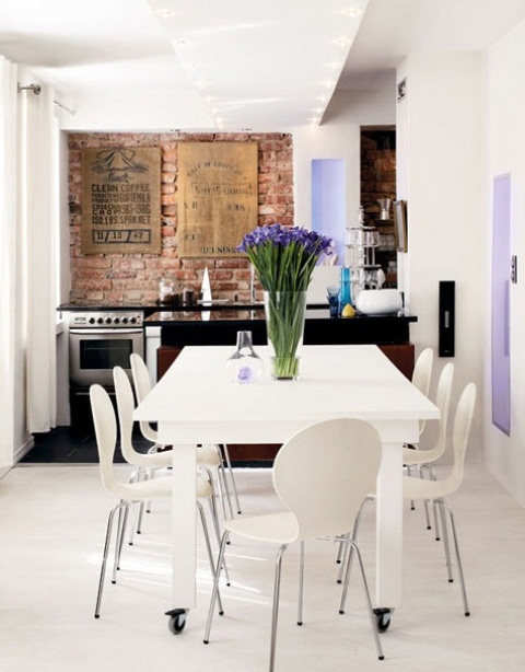 an eclectic kitchen in white and lavender with a red brick backsplash as a bright textural element