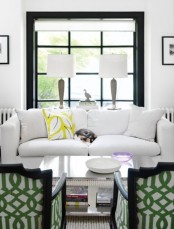 a mid-century modern meets art deco living room with touches of black for drama and some bright prints