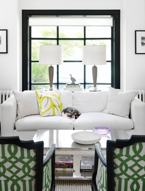 A mid century modern meets art deco living room with touches of black for drama and some bright prints