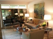 a neutral living room with an artwork, plaid furniture, prints and lamps for a welcoming and cozy look