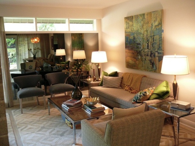 A neutral living room with an artwork, plaid furniture, prints and lamps for a welcoming and cozy look