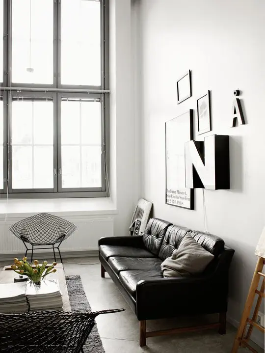A Nordic meets mid century living room done in a monochromatic color scheme and a cool gallery wall