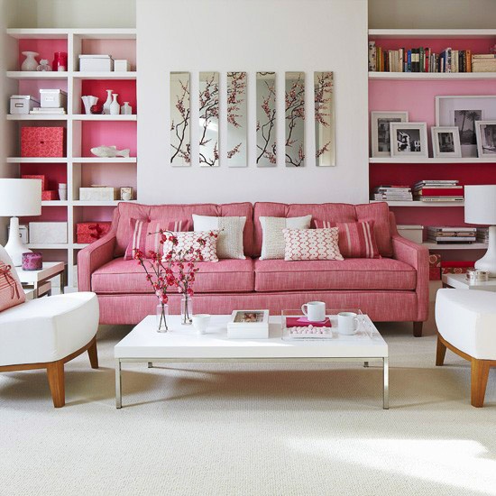 A pink and white mid century modern living room with built in shelves with backing and floral artworks