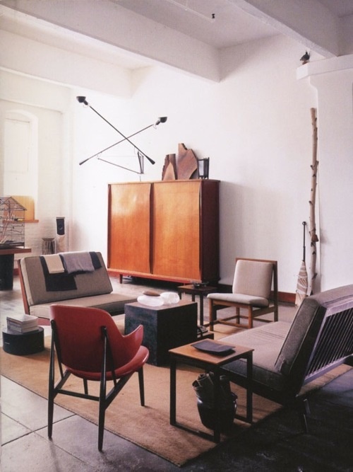 a mid-century modern living room with grey and creamy furniture, a plywood cabinet and some catchy lamps