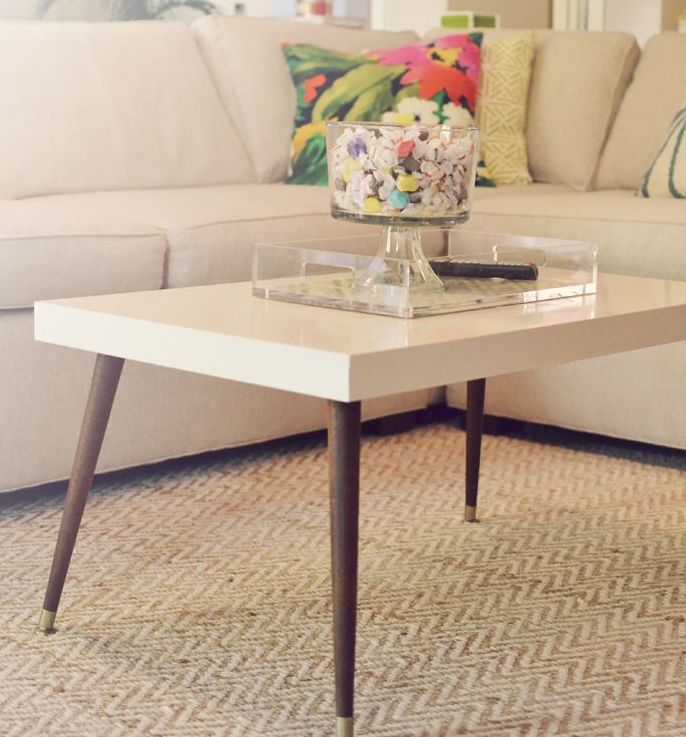 A mid century modern coffee table with a white tabletop and dark stained tapered legs is a lovely idea that will match most of interiors