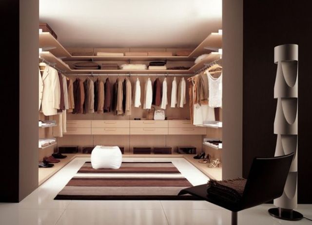 A minimalist closet done of neutral colored plywood, lots of lights and a striped rug for a cozy touch
