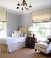 neutral and grey Roman shades highlight the elegance of the bedroom and block out the sun when needed