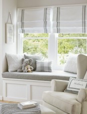 a stylish window nook protected with roman shades