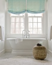 green Roman shades make the bathroom more welcoming and cozy, and adds a delicate touch of color to the space