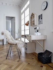a Nordic white home office with a wall-mounted desk, a cabinets for storage, a house-shaped wall-mounted shelf and a cane chair
