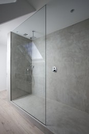 an ultra-minimalist concrete bathroom with a shower space clad with glass is a very elegant and chic space to be