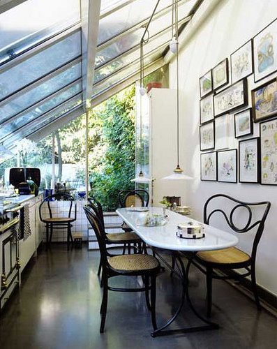 A kitchen with glass roof and floor to ceiling windows is awesome place for cooking. A gallery wall only makes it more cozy.