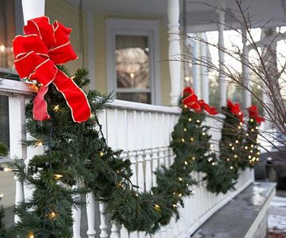 An evergreen garland with lights and red bows is a pretty outdoor decoration for Christmas, it will easily turn the exterior of your home into Christmas like