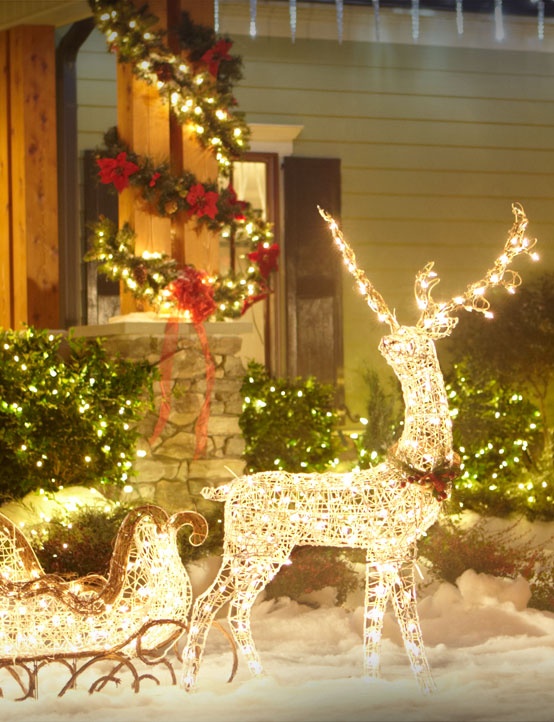 a deer with a sleigh composed of lights, an evergreen and light garland covering the pillar are amazing for creating a Christmas scene