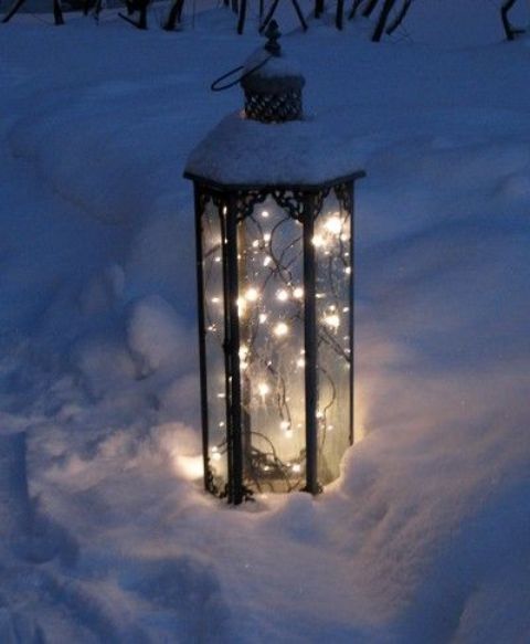 a lantern with lights placed right into the snow will give your space a gorgeous winter wonderland feel