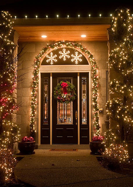 lit up evergreen garlands covering the pillars and framing the door will make your entrance very Christmassy