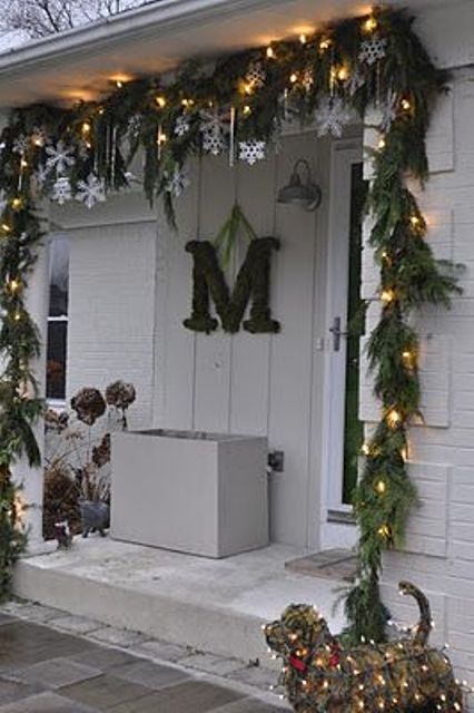 An evergreen and light garland, snowflakes and icicles make the porch very holiday like and give it a fresh feel
