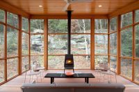 super cozy sunroom filled with natural wood and a wood-burning stove