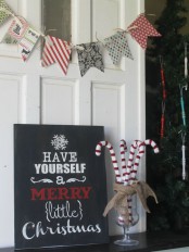 a simple black Christmas sign with white and red letters is a stylish idea for more modern holiday decor and styling
