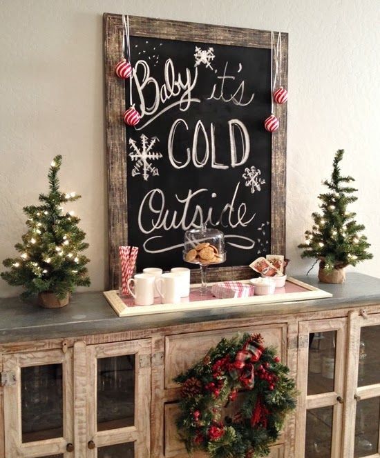 a chalkboard Christmas sign with a rustic wooden frame, red and white swirl ornaments and white chalked letters is amazing