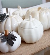white porcelain pumpkins and white pumpkins for decor with dark leaves will make your space chic and vintage-inspired
