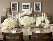 a refined neutral and white Thanksgiving table with white candles, blooms napkins, grey cards and mugs is very refined