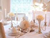 a vintage white Thanksgiving tablescape with white porcelain, pumpkins, blooms in silver candleholders is chic and bold