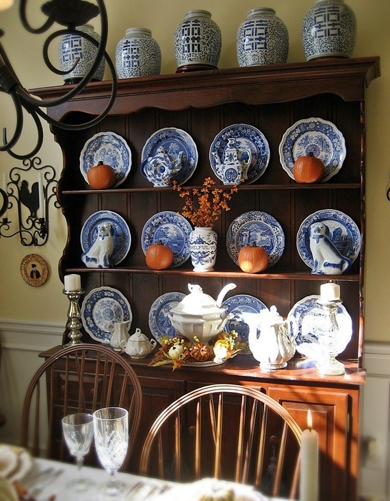 A chic Thanksgiving display with blue and white plates and orange pumpkins for a contrast is a very cool idea to try