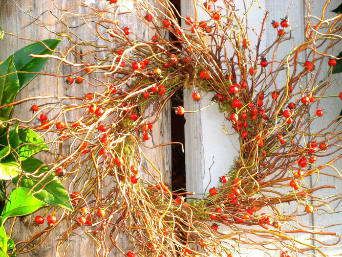 A lovely all natural wreath of branches, greenery and berries and moss is a chic fall or Thanksgiving decoration