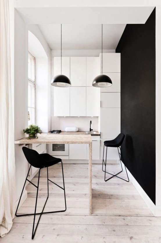a small and minimal dining space with just a bar counterop and black stools plus black pendant lamps is awesome
