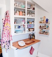 a tiny white kitchen with an open cabinet with shelves, a butcherblock countertop and some shelves for storage on the wall