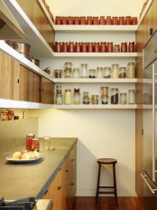 a small minimalist kitchen with wooden cabinets and concrete countertops, upper cabinets and open shelves to use every inch of space