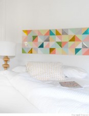 a neutral bedroom design with a colorful artwork