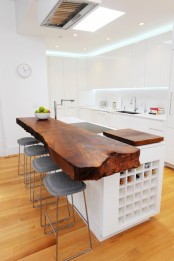 a modern sleek kitchen island with a rich stained countertop with a living edge for a contrasting look