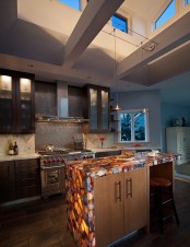 rich stained and light stained cabinets with an onyx coutnertop with built-in lights to accent the countertop even more