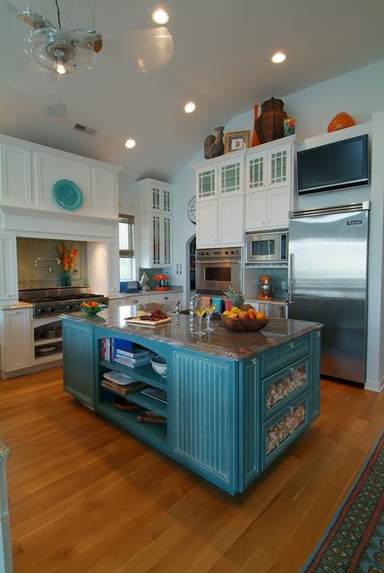 a bright blue vintage kitchen island with a stone countertop, open and closed storage compartments