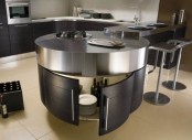 a round kitchen island of dark stained wood and metal on top plus an additional counter that can serve a breakfast bar or a drink one