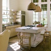 a large whitewashed wooden kitchen island stands out with its color and finish and adds a relaxed feel to the space