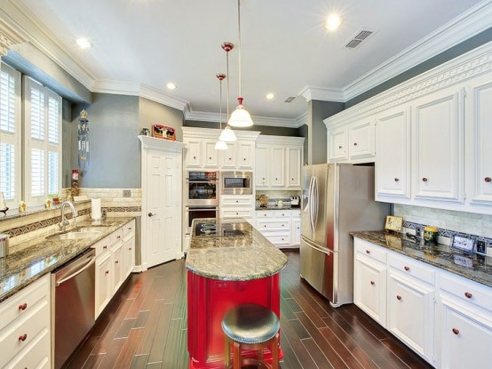 a long curved hot red kitchen island with a stone countertop is a great idea for  anarrow kitchen, it won't take much space